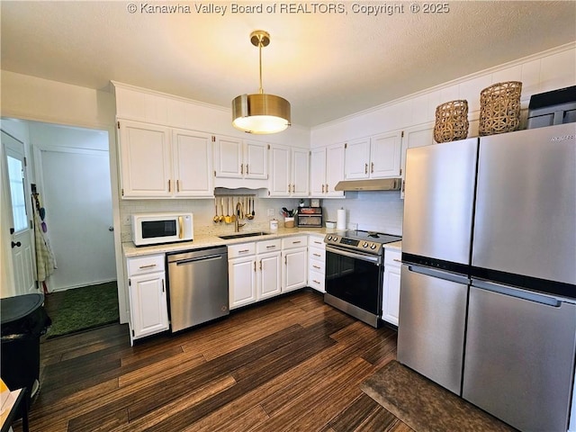 kitchen featuring a sink, light countertops, white cabinets, appliances with stainless steel finishes, and under cabinet range hood