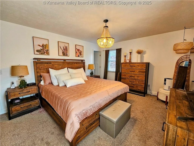 carpeted bedroom featuring a notable chandelier, a textured ceiling, and baseboards