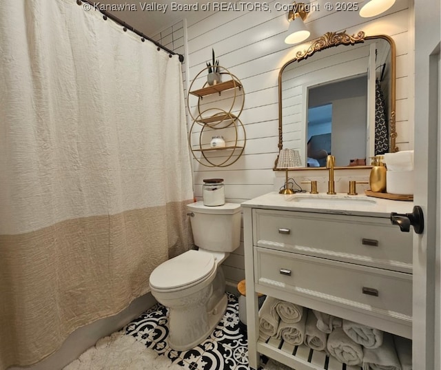 bathroom featuring tile patterned flooring, wood walls, toilet, a shower with shower curtain, and vanity