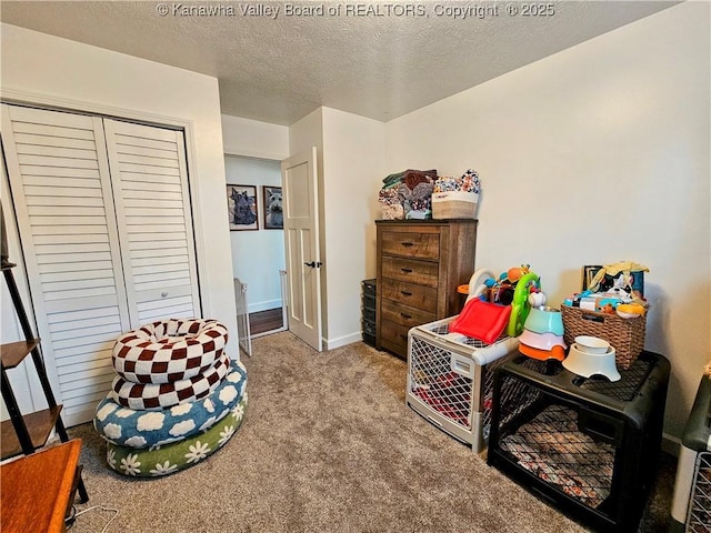 bedroom with a closet, baseboards, a textured ceiling, and carpet flooring