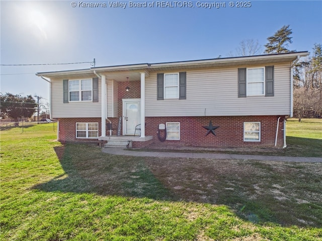 raised ranch featuring brick siding and a front yard