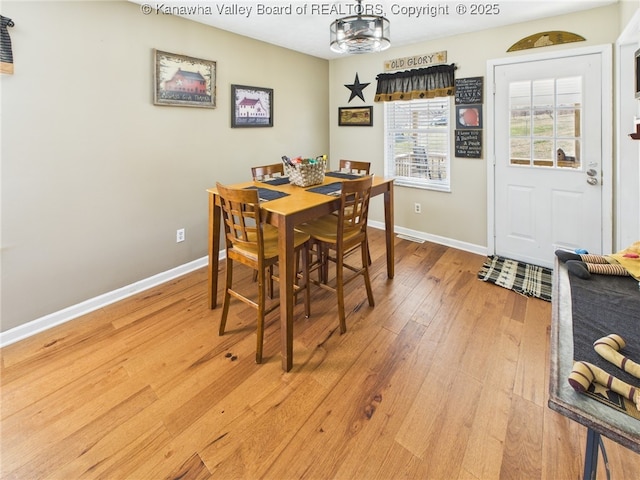 dining space featuring light wood-style floors and baseboards