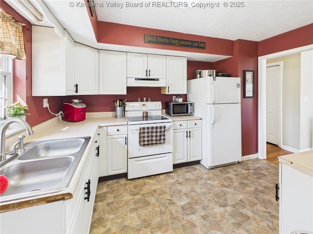 kitchen with under cabinet range hood, a sink, white appliances, white cabinets, and light countertops