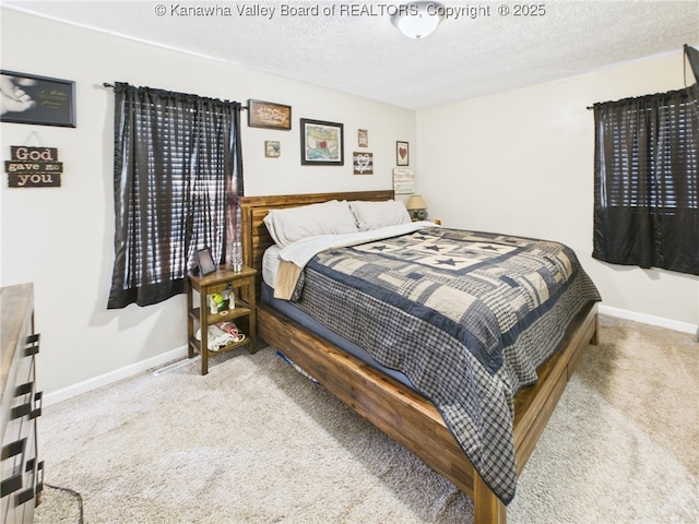 carpeted bedroom with baseboards and a textured ceiling