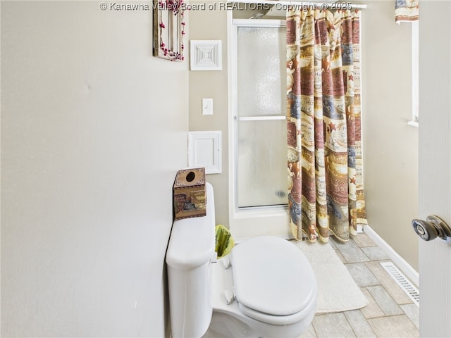 bathroom with baseboards, a shower with curtain, and toilet