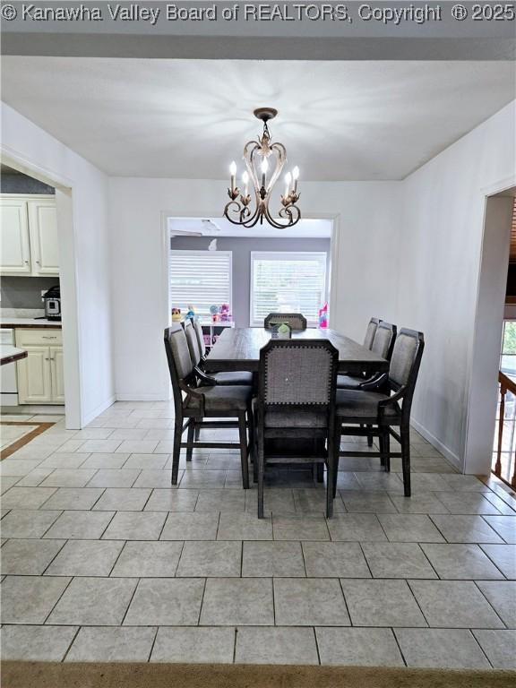 dining space featuring light tile patterned flooring, a notable chandelier, plenty of natural light, and baseboards