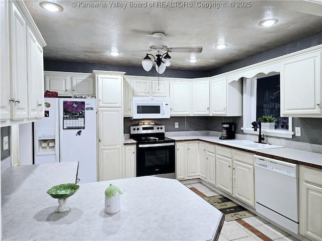 kitchen with white cabinetry, white appliances, recessed lighting, and a sink