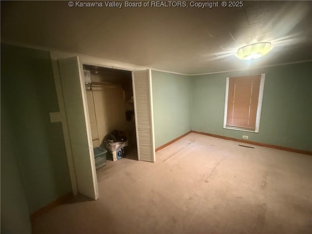 unfurnished bedroom featuring carpet, baseboards, and a closet