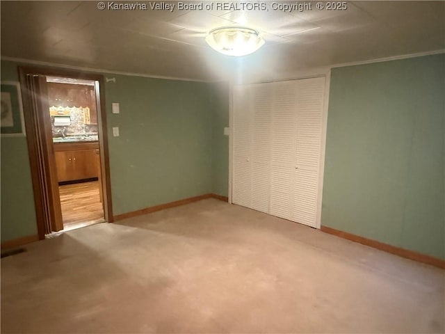 unfurnished bedroom with a closet, baseboards, and carpet flooring