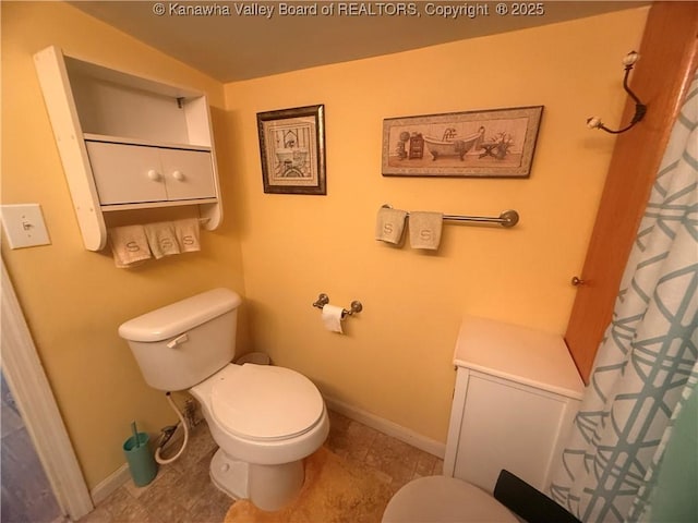 bathroom featuring toilet and baseboards