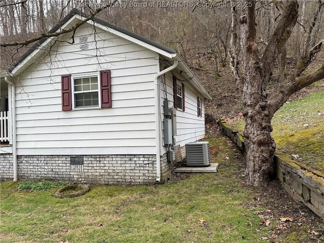 view of side of home with central air condition unit and a lawn