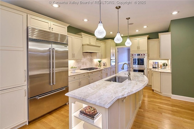 111 Graff Ln, Charleston, WV 25304 - kitchen featuring stainless steel appliances, a sink, light wood finished floors, backsplash, and a center island with sink