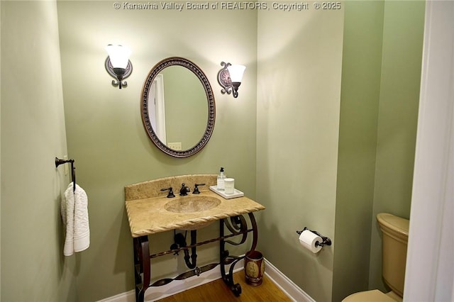111 Graff Ln, Charleston, WV 25304 - half bathroom featuring toilet, baseboards, a sink, and wood finished floors