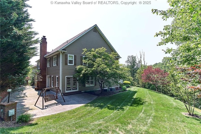 111 Graff Ln, Charleston, WV 25304 - back of house featuring a chimney, a yard, and a patio