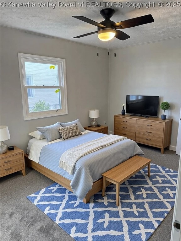 bedroom with ceiling fan, carpet, and a textured ceiling
