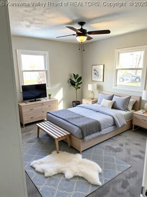 bedroom with a ceiling fan, a textured ceiling, and carpet flooring