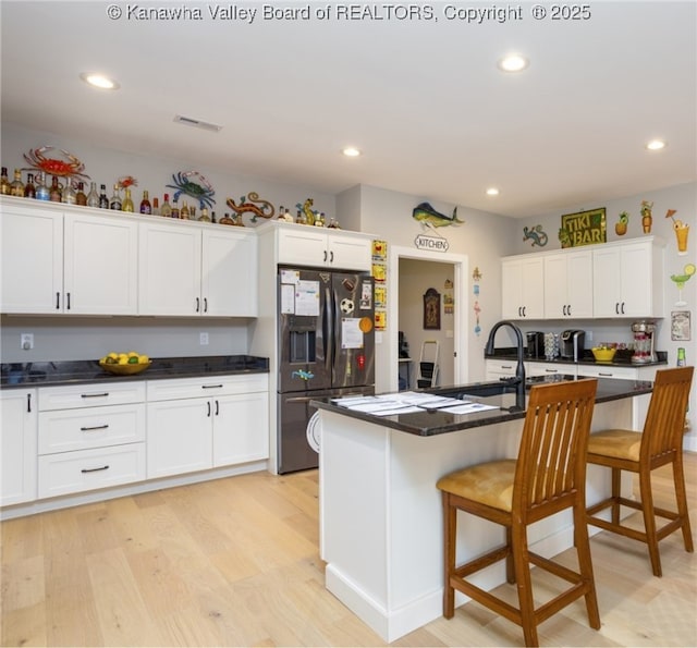 225 Woodland Dr, Milton, WV 25541 - kitchen with light wood-style floors, a breakfast bar area, stainless steel fridge, visible vents, and recessed lighting