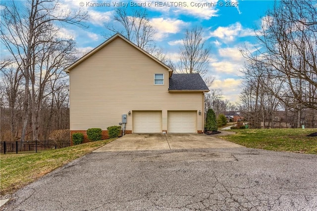 view of side of property featuring fence, an attached garage, a shingled roof, concrete driveway, and a lawn