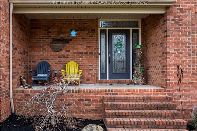 doorway to property featuring brick siding