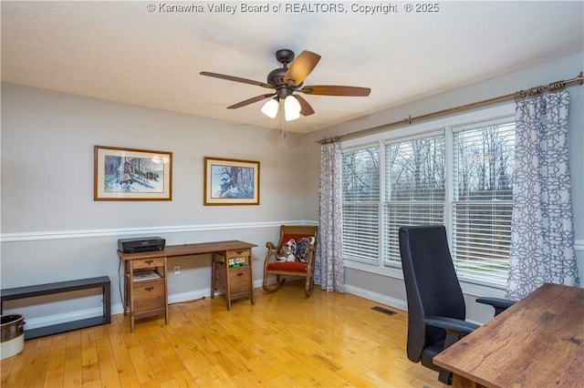 office space with wood-type flooring, baseboards, ceiling fan, and visible vents