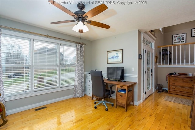 office space featuring baseboards, light wood finished floors, ceiling fan, and visible vents