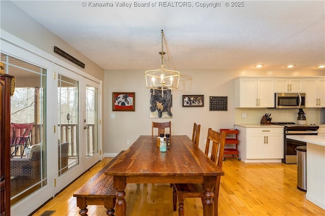 dining room with recessed lighting, a chandelier, french doors, and light wood-type flooring