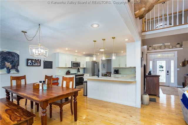 dining area featuring light wood finished floors and a notable chandelier