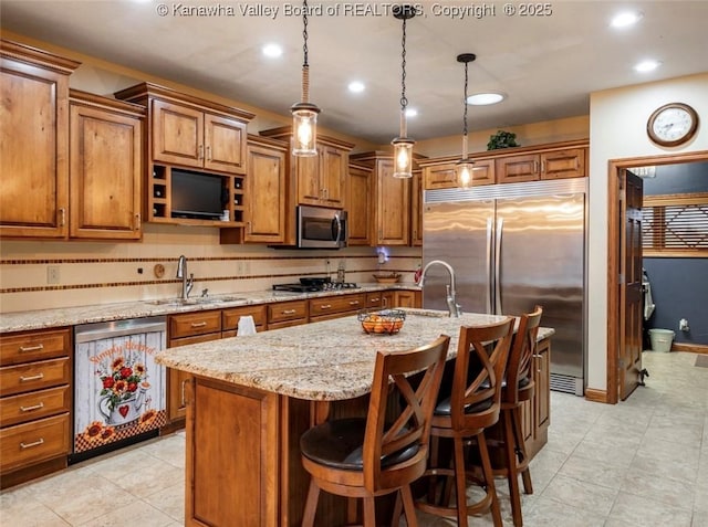 356 Latigo Pt, Milton, WV 25541 - kitchen with stainless steel appliances, brown cabinetry, an island with sink, light stone countertops, and light tile patterned floors