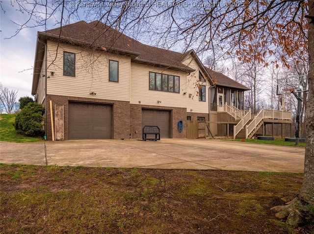356 Latigo Pt, Milton, WV 25541 - view of front of house featuring driveway, an attached garage, stairs, and brick siding