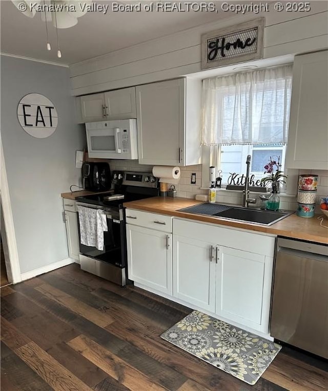 kitchen with decorative backsplash, a sink, stainless steel appliances, and dark wood-type flooring