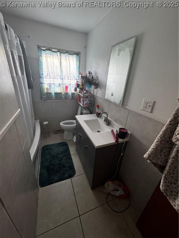 full bath with tile walls, toilet, tile patterned flooring, and vanity