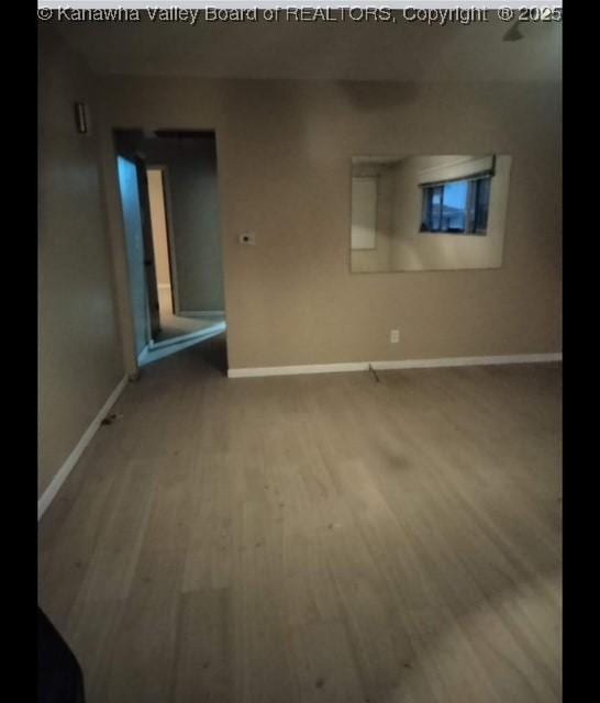 interior space featuring baseboards and wood finished floors