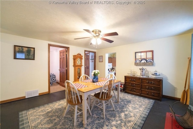 dining room with a textured ceiling, visible vents, baseboards, and a ceiling fan