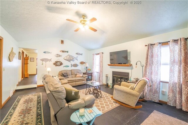 living room featuring a textured ceiling, vaulted ceiling, ceiling fan, and a healthy amount of sunlight