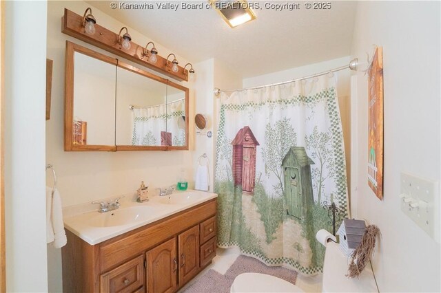 bathroom featuring a shower with curtain, double vanity, toilet, and a sink