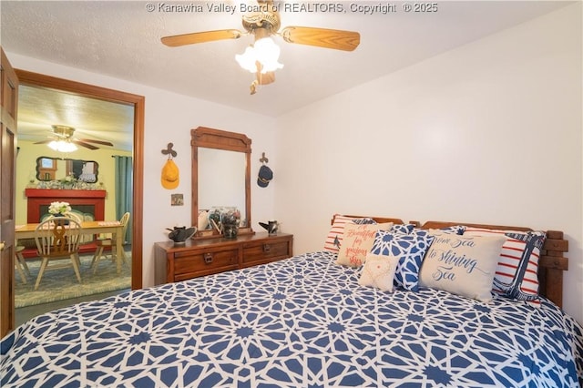 bedroom featuring a textured ceiling, carpet, and ceiling fan