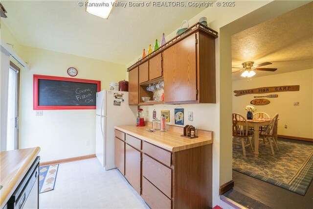 kitchen featuring a ceiling fan, light countertops, baseboards, and white appliances