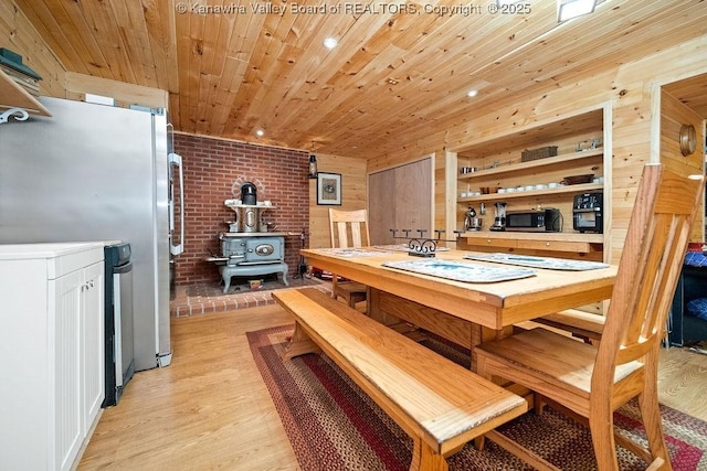 510 Shamrock Dr, Union, WV 26833 - dining room featuring a wood stove, light wood-style floors, wood ceiling, and brick wall