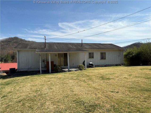 rear view of property featuring a lawn and crawl space