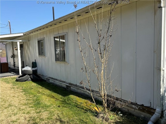 view of side of home with a lawn and board and batten siding