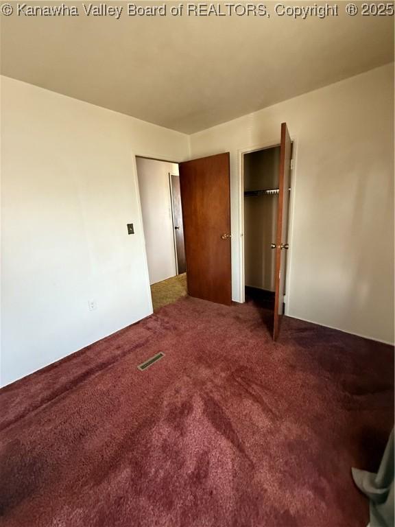 unfurnished bedroom with visible vents and carpet