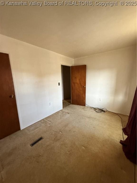 spare room featuring visible vents and carpet