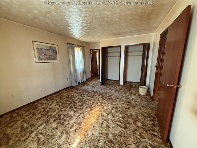 unfurnished bedroom with baseboards, two closets, carpet flooring, and a textured ceiling