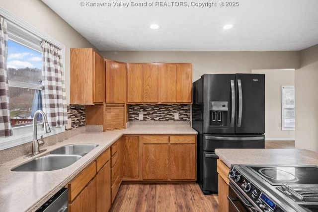 25 Lilly Hls, South Charleston, WV 25309 - kitchen featuring a sink, light wood-style floors, stainless steel appliances, light countertops, and backsplash