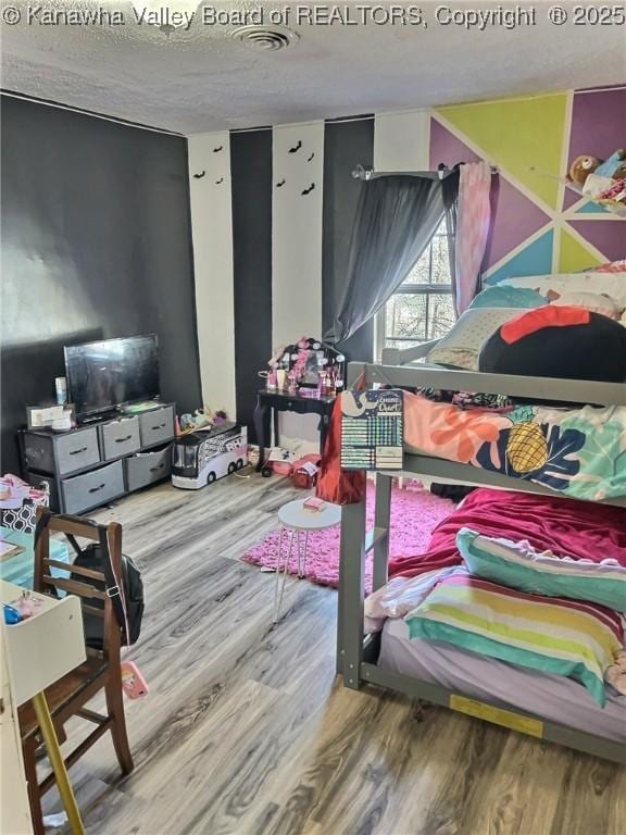 bedroom featuring a textured ceiling and wood finished floors