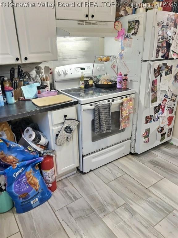 kitchen featuring white cabinetry, under cabinet range hood, and white appliances