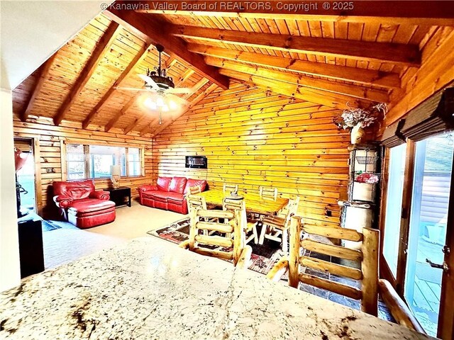 interior space with wooden walls, wooden ceiling, carpet, and lofted ceiling with beams