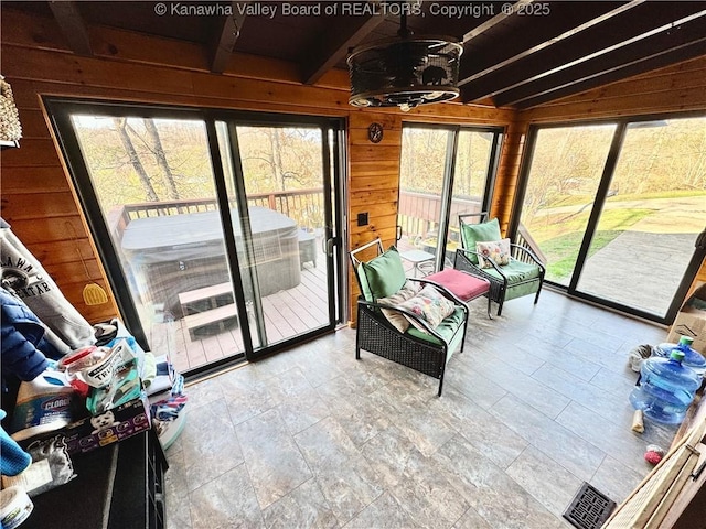 sunroom / solarium with wooden walls, a notable chandelier, visible vents, and vaulted ceiling with beams