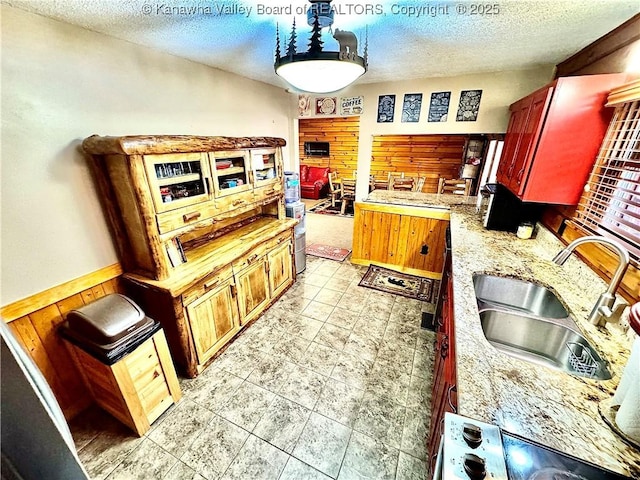 kitchen with light countertops, a textured ceiling, and a sink