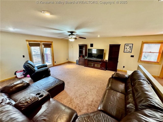 carpeted living area featuring baseboards and a ceiling fan